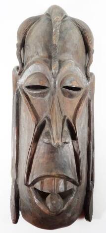 An African tribal wooden face mask, with enlarged features, 57cm H.