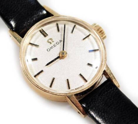 A ladies Omega Cocktail watch, with baton numerals and pointers, with a black leather strap.