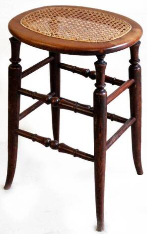 An early 20thC cane seated stool, the oval top raised on four turned legs, 53cm H, 36cm W, 30cm D.