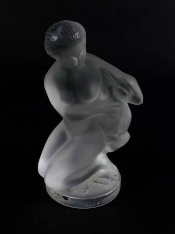 A Lalique frosted glass figure of Diana, Goddess of The Hunt, modelled kneeling with a young dear under her arm, raised on a clear glass circular base, etched Lalique France, bears labels, 11.5cm H.