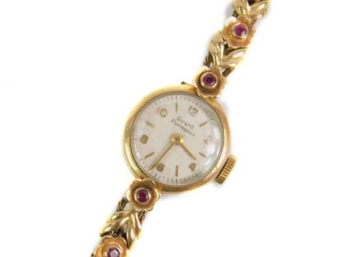 A Girard Perregaux lady’s 9ct gold wristwatch, circular dial bearing Arabic numerals and batons, on a ruby set floral bracelet, 18.3g all in. (AF)