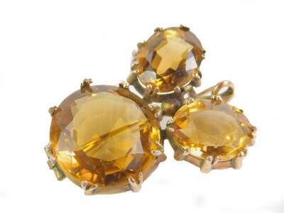 A Victorian citrine three stone brooch, with one brilliant and two oval cut citrines, set in yellow metal, largest stone approx 17cts, 9.9g.