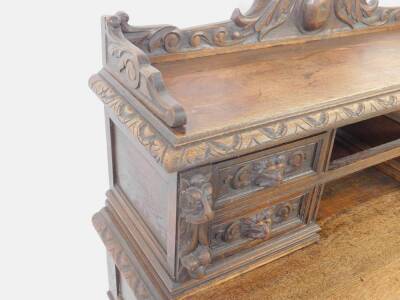 A Victorian oak desk, the upper super structure having a galleried top, carved with scrolling leaves and flowers, over four short drawers with carved lion mask handles and scrolling decoration, over one medium and four short drawers, similarly carved, rai - 4