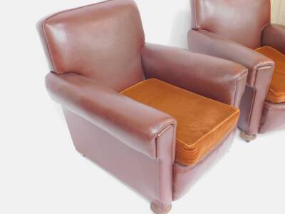 A pair of early 20thC armchairs, later reupholstered in brown leatherette, raised on oak bun feet, on castors. - 2