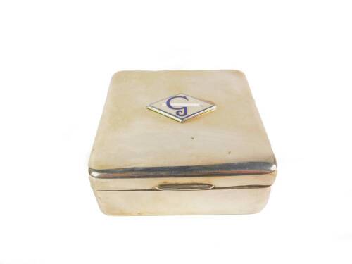 A silver square cigarette box, decorated to the lid with a plaque bearing a smoking cigarette and the letter G in blue and white enamel, Birmingham 1958, 8.5cm W, 7.23oz.