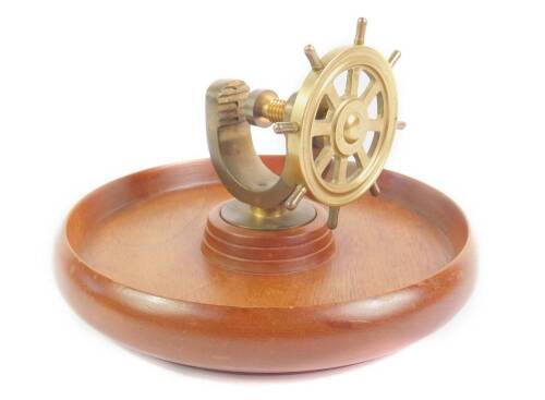 A brass capstan wheel nutcracker, raised on a turned beech wood bowl, 21cm dia.