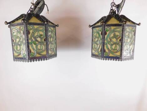 A pair of Tiffany style octagonal lanterns, decorated with panels of scrolling leaves against a pearl ivory ground, 36cm dia.