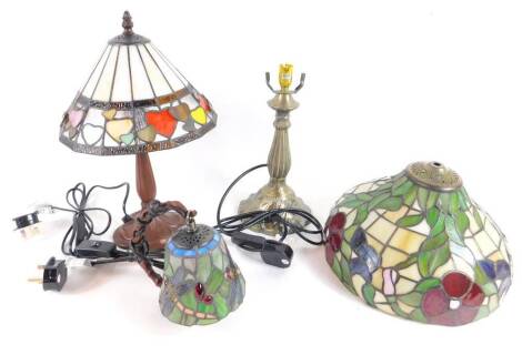 *A Tiffany style table lamp, with a heart shaped decorated shade, raised on a faux metal base, 40cm H, further Tiffany style lamp and shade, decorated with flowers, and a dragonfly decorated wall light, (AF). (3)