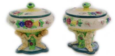 A pair of Maruhon ware Japanese pottery bowls and covers, moulded with flowers, raised on a stem with child supports, on a triform base, 12cm H.