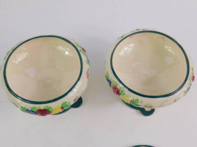 A pair of Maruhon ware Japanese pottery bowls and covers, moulded with flowers, raised on a stem with child supports, on a triform base, 12cm H. - 2