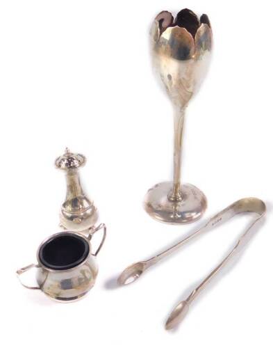 An Edward VII silver tulip bud vase, Sheffield 1907, a pair of Victorian silver sugar tongs, London 1879 and a silver salt and pepperette, hallmarks indistinct, 6.09oz.