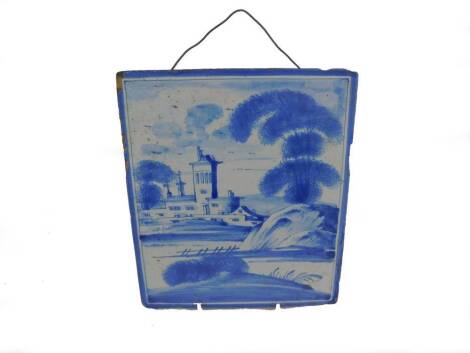 An English 18thC Delft ware tile, painted in blue and white with a manor house in a river landscape, 21.5cm H, 19cm W.