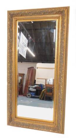 A rectangular gilt wood wall mirror, inset bevelled glass, with leaf moulded decoration, 187cm H, 95cm W.