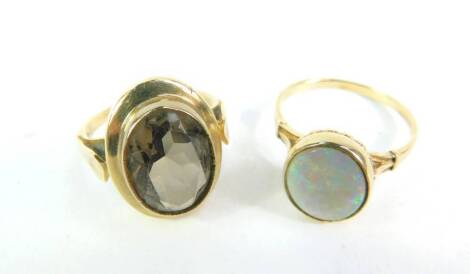 A smokey quartz ring, size P/Q, set in yellow metal, and a 9ct gold and opal ring, size T, 8.6g. (2)