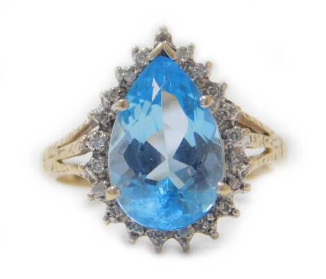 A 9ct gold aquamarine and diamond ring, the pear shaped aquamarine surrounded by tiny diamonds, with pierced fan design shoulders, on a plain band, aquamarine approx 3.75cts, size R, 3.8g all in.