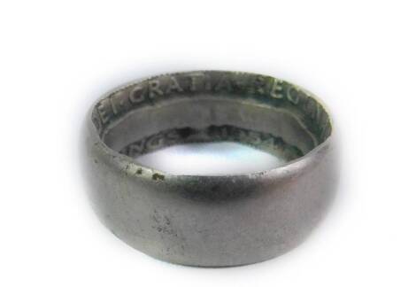 A plain wedding band, with two shilling 1954 hammered coin interior, marked Elizabeth II.