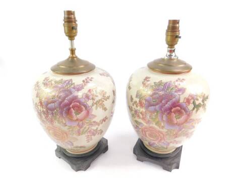 A pair of Chinese pottery table lamps, enamel decorated with flowers, raised on a square canted wooden base, 37cm H.