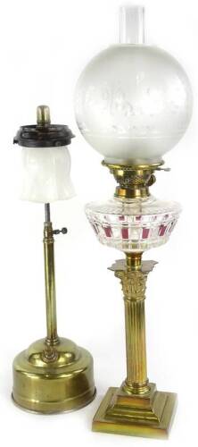 A late 19th/early 20thC brass Bohemian style oil lamp, the etched type frosted shade, decorated with swags, bows etc., above a part ruby and clear glass reservoir, the base cast in the form of a Corinthian column on square foot, 74cm H, and a Tilly lamp.