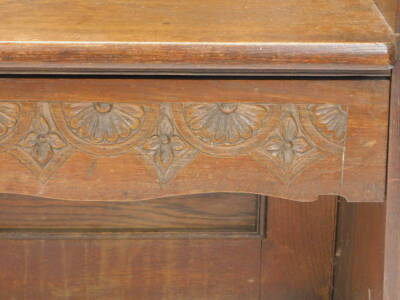 An early 20thC oak settle with a carved panelled back shaped sides and double seat, 107cm W. - 3