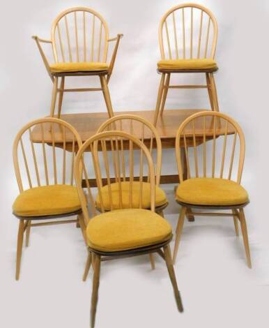 An Ercol blonde elm extending dining or kitchen table, with a moulded edge, rounded corners on trestle type supports, the top 92cm x 149cm, and six kitchen chairs, one with arms.