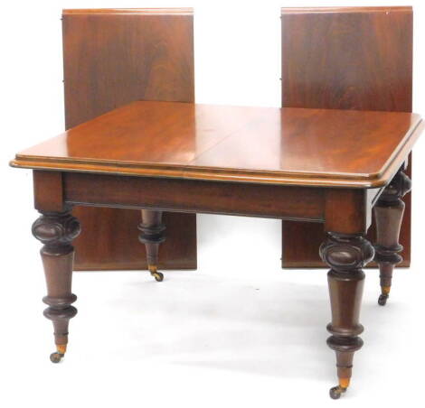 A Victorian mahogany extending dining table, the rectangular top with a moulded edge on turned and carved legs with ceramic castors, two loose leaves, the top 114cm x 238cm.