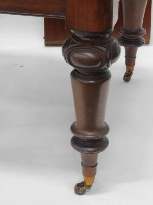 A Victorian mahogany extending dining table, the rectangular top with a moulded edge on turned and carved legs with ceramic castors, two loose leaves, the top 114cm x 238cm. - 2