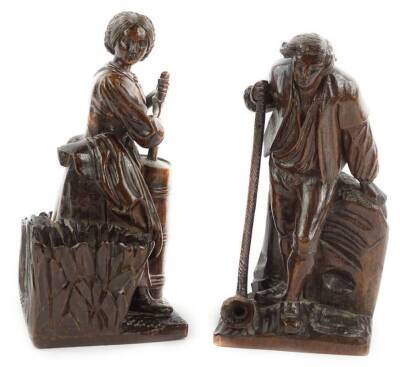 A pair of early 18thC Continental walnut carvings, one depicting a gentleman with a long pipe, 22cm H, the other a lady carrying baskets beside a barrel, 24cm H.