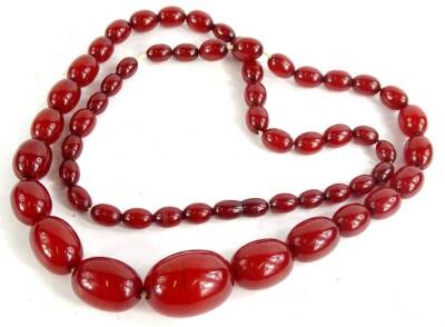 A cherry amber beaded necklace, with graduated amber beads, the largest 4cm W, the smallest 1cm W, on plain string, 69.7g all in.