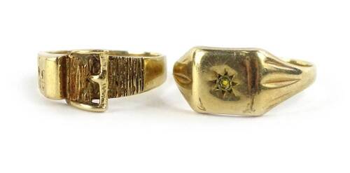 Two 9ct gold dress rings, one of buckle design, the other a signet ring set with tiny white paste stone, 5.9g all in.