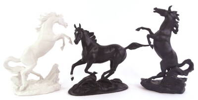 A pair of Franklin Mint porcelain figures of the Battling stallions, By Edward D Heart, one black the other in white, and a Black Beauty figure designed by Pamela du Boulay. (3)