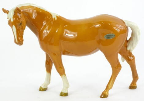 A Beswick Palomino horse, with two front 'socks', paper label, 17cm H.