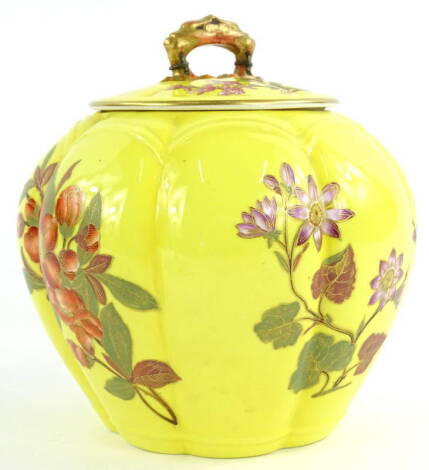 A Royal Worcester porcelain jar and cover, decorated with oriental style flowers on a yellow ground, printed in puce to underside, 16cm W.