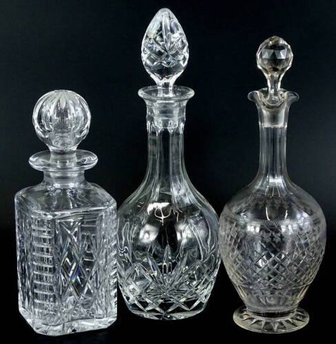 An Edwardian cut and etched decanter and stopper, and two crystal decanter and stoppers. (3)