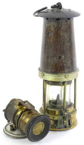 A brass and iron miner's lamp, unmarked, and a small Premiere brand lamp.