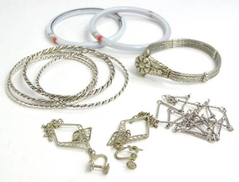 A quantity of silver and silver plated jewellery, to include four silver bangles, silver plated necklace, silver plated filigree design drop earrings, Tibetan bangle, and two textured bangles. (a quantity)