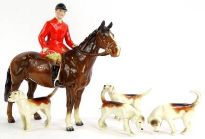 A Beswick ceramic model of a huntsman on a brown horse, and four hounds. (AF)