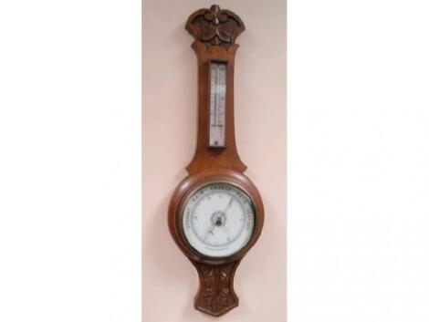 An Edwardian carved oak cased aneroid barometer