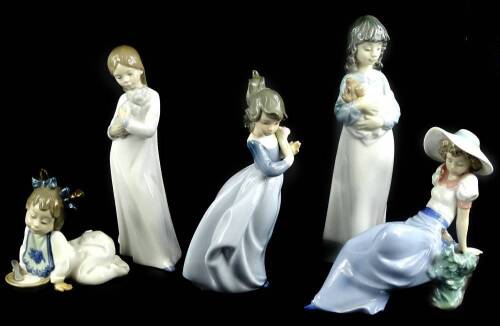 Five Nao porcelain figures, two modelled with puppies, child with a bird, child with flowers, etc.