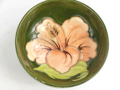 A Moorcroft pottery bowl, decorated with a peach coloured flower, on a green ground, impressed mark to underside, 11.5cm diameter. - 2