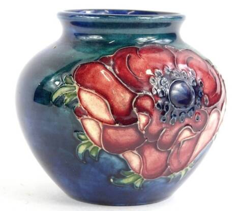 A Moorcroft pottery vase, decorated with poppies, on a blue and green mottled ground, impressed mark to underside, 7cm H.