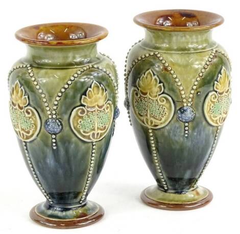 A pair of Doulton Lambeth stoneware vases, decorated in Art Noveau style, with flowers, leaves, etc., on a blue and green mottled ground, impressed marks to underside, 17cm H.