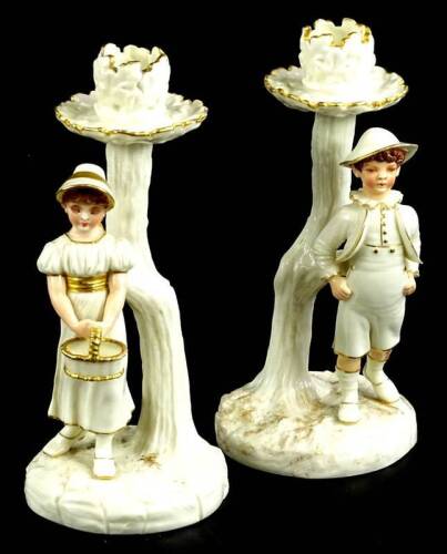 A pair of Royal Worcester porcelain candlestick figures, each applied with a male and female figure, printed mark to underside, 21cm H.