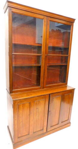 A Victorian walnut bookcase, the top with two glazed doors, above two panelled doors on a plinth, 216cm H, 124cm W.