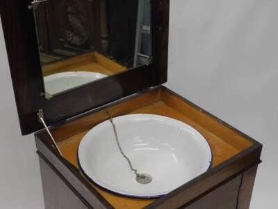 An oak wash stand cabinet, the hinged top enclosing a mirror and an enamel wash bowl with plug, etc., the door with further fitting enclosing a shelf, on bracket feet, 92cm H, 59cm diameter. - 2