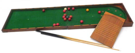 A late 19th/ early 20thC mahogany folding billiards game, with a baize interior, later cues and accessories and a shove halfpenny board. 55cm x 107cm enclosed.