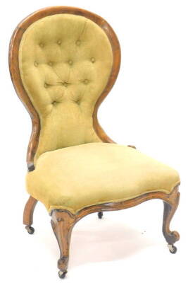 A Victorian walnut show frame spoonback nursing chair, with a button back and padded seat on cabriole legs, with castors.