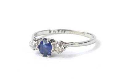 A sapphire and diamond three stone dress ring, of small proportions, set with oval cut and claw set sapphire, and two small round brilliant cut diamonds, on white metal band, marked 18ct and plat, 1.6g all in.