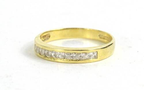 An 18ct gold diamond set dress ring, set with ten square cut diamonds in channel setting, 2.7g all in.