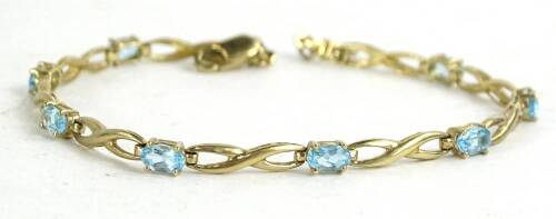 A 9ct gold aquamarine set bracelet, with scroll design broken up by oval cut aquamarines, in claw setting, 4.3g, 51cm L overall.