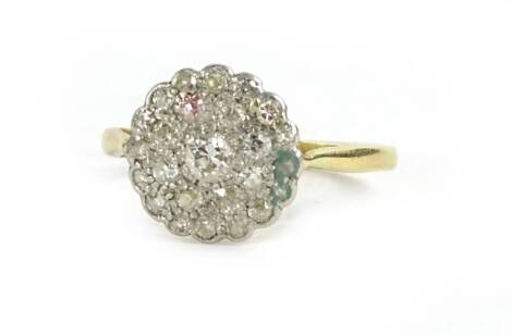 A diamond floral cluster ring, with pave set tiny diamonds, the central diamond approximately 0.1carat, with pierced design shoulders, yellow metal marked 18ct, 3g all in.